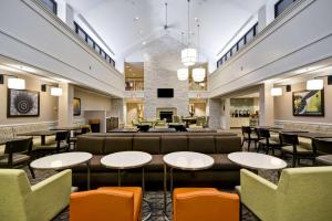 a lobby of a hotel with tables and chairs at Homewood Suites Dulles-International Airport in Herndon