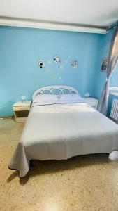 a bedroom with a bed with a blue wall at Domi B & B in Macerata