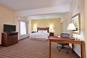 a hotel room with a bed and a desk at Hampton Inn Gainesville-Haymarket in Gainesville