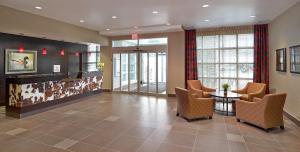 a lobby with a waiting room with a table and chairs at Homewood Suites Calgary Airport in Calgary