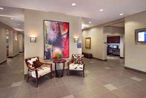 a lobby with two chairs and a painting on the wall at Homewood Suites Calgary Airport in Calgary