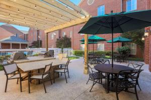 a patio with tables and chairs and umbrellas at Homewood Suites Nashville Airport in Nashville