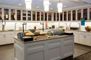 a large kitchen with a counter with food on it at Homewood Suites Nashville Airport in Nashville