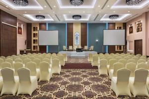 Hilton Alexandria King's Ranch Hotel في الإسكندرية: قاعة اجتماعات بها كراسي وشاشات فارغة