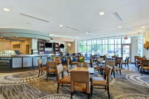 a restaurant with tables and chairs and a bar at DoubleTree by Hilton Baton Rouge in Baton Rouge