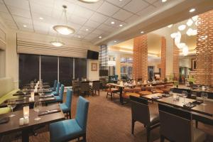 un restaurante con mesas de madera y sillas azules en Hilton Garden Inn Wilkes-Barre en Wilkes-Barre