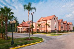 a hotel with palm trees and a building at Homewood Suites by Hilton Houston-Woodlands-Shenandoah in The Woodlands