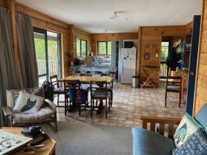 a kitchen and living room with a table and chairs at Waikawa Bay bach with spectacular views in Waikawa