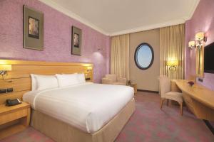 ein Hotelzimmer mit einem großen Bett und einem Schreibtisch in der Unterkunft DoubleTree by Hilton Dhahran in Khobar