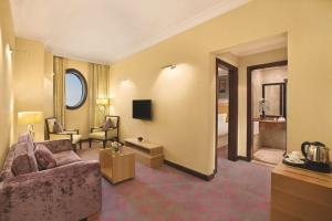 a living room with a couch and a television in a room at DoubleTree by Hilton Dhahran in Al Khobar
