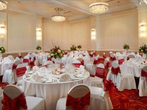 um salão de banquetes com mesas brancas com arcos vermelhos em Hilton London Paddington em Londres