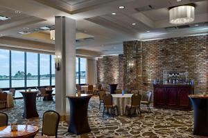 a dining room with tables and chairs and a large window at Hilton New Orleans Riverside in New Orleans