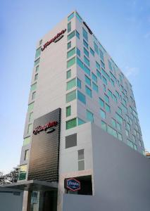 wysoki budynek z znakiem na boku w obiekcie Hampton by Hilton Panama w Panamie