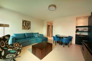 a living room with a blue couch and a table at Hampton by Hilton Panama in Panama City