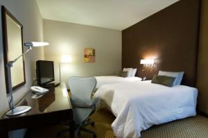 a hotel room with two beds and a desk with a computer at Hilton Garden Inn Riyadh Olaya in Riyadh