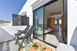 a balcony with glass doors and a table and chairs at Los Canarios 630 by VillaGranCanaria in Patalavaca +31 photos