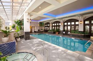 a swimming pool in a building with a large lobby at Embassy Suites San Francisco Airport - Waterfront in Burlingame