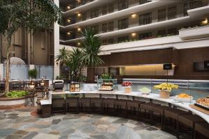 a lobby of a hotel with a buffet of food at Embassy Suites San Francisco Airport - Waterfront in Burlingame