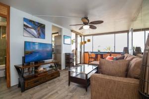a living room with a couch and a flat screen tv at Kealia Resort 601 in Kihei