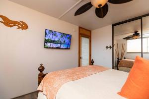 a bedroom with a bed and a flat screen tv on the wall at Kealia Resort 601 in Kihei +29 photos