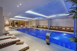 una piscina de hotel con tumbonas y un bar en DoubleTree by Hilton Hotel Istanbul - Tuzla, en Estambul