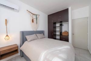 1 dormitorio con cama blanca y armario negro en The Smurfs Townhome. Pool / FREE parking., en Puerto Morelos 15 fotos más