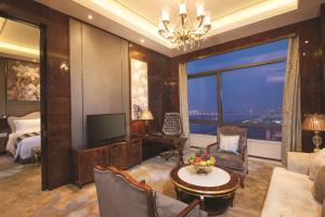 a living room with a television and a bedroom at DoubleTree By Hilton Anhui in Suzhou