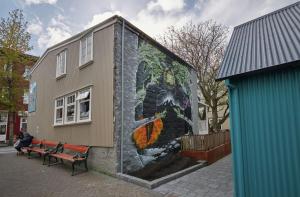 a mural on the side of a building with a bench at Canopy by Hilton Reykjavik City Centre in Reykjavík