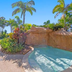 una piscina en un complejo con palmeras en The Mirage Resort Alexandra Headland, en Alexandra Headland