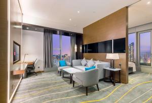 una camera d'albergo con divano e scrivania di Hilton Garden Inn Hong Kong Mongkok a Hong Kong