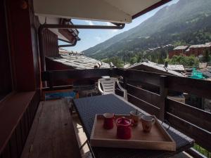 Un balcón con una mesa con tazas. en Charmant 2 pièces pour 5 pers avec balcon, service linge inclus ! - FR-1-291-877, en Valmorel 3 fotos más