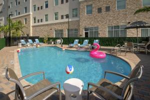 - une piscine avec un cygne rose et des chaises dans l'établissement Hampton Inn Miami Airport East, à Miami