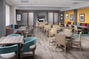 a restaurant with tables and chairs and a television at Hampton Inn Miami Airport East in Miami