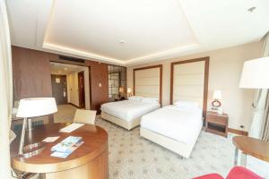 Una habitación de hotel con dos camas y un escritorio. en Doubletree By Hilton Istanbul Topkapi, en Estambul