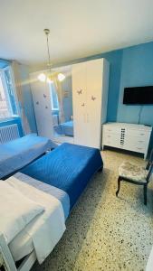 a blue bedroom with two beds and a chair at Domi B & B in Macerata