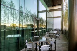 um restaurante com mesas e cadeiras e grandes janelas de vidro em Hilton Garden Inn Aguascalientes em Aguascalientes