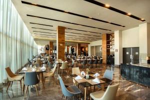 a restaurant with tables and chairs in a building at Hilton Garden Inn Aguascalientes in Aguascalientes