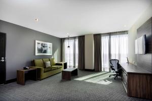 a hotel room with a couch and a desk at Hilton Garden Inn Aguascalientes in Aguascalientes