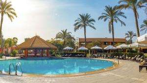 a swimming pool with a gazebo and palm trees at Hilton Cairo Heliopolis Hotel in Cairo