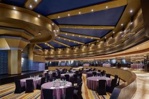 un salón de banquetes con mesas, sillas y techos en Hilton Cairo Heliopolis Hotel, en El Cairo