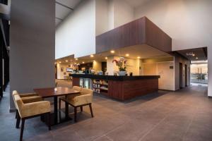 a lobby with a table and chairs and a bar at Hampton Inn By Hilton San Luis Potosi in San Luis Potosí