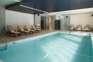 a large swimming pool with chairs and a table at Embassy Suites by Hilton South Bend in South Bend