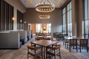 南本德Embassy Suites by Hilton South Bend的有桌椅和窗户的餐厅