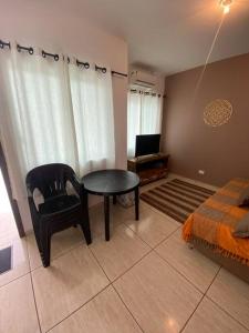 a room with a table and a chair and a television at Casa a poucos metros da praia! in Guaratuba +18 photos