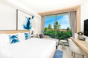 a hotel room with a bed and a large window at Hilton Garden Inn Phuket Bang Tao in Bang Tao Beach