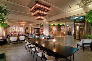 a hotel lobby with a large table and chairs at Hart Shoreditch Hotel London, Curio Collection by Hilton in London