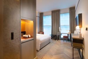 a hotel room with a bed and a desk at Hart Shoreditch Hotel London, Curio Collection by Hilton in London