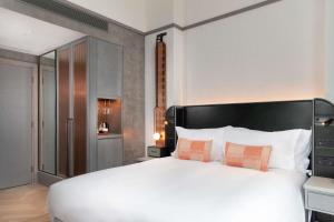 um quarto com uma grande cama branca e 2 almofadas em Hart Shoreditch Hotel London, Curio Collection by Hilton em Londres
