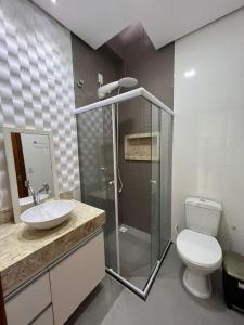 a bathroom with a toilet and a sink and a shower at Villa dos Diamantes - 16 in Porto Seguro