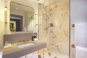 a bathroom with a sink and a shower at Hart Shoreditch Hotel London, Curio Collection by Hilton in London